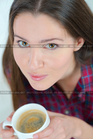 Woman drinking a cup of coffee on the sofa. Стоковое фото, агентство Ingram Publishing / Фотобанк Лори