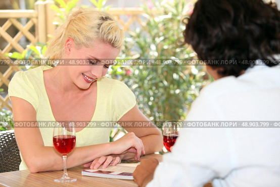 Woman drinking a glass of wine and looking at a book. Стоковое фото, агентство Ingram Publishing / Фотобанк Лори