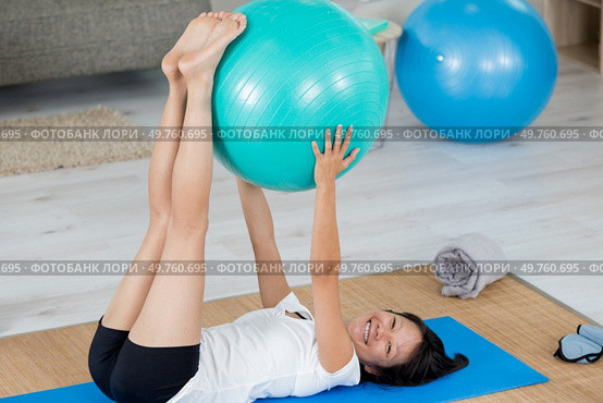 woman exercising at home with aerobic ball. Стоковое фото, агентство Ingram Publishing / Фотобанк Лори