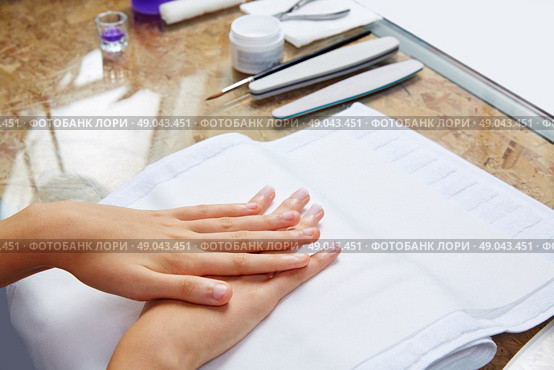 woman hands with nails before treatment on white towel in salon. Стоковое фото, агентство Ingram Publishing / Фотобанк Лори