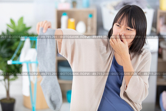 woman holding dirty stinky socks. Стоковое фото, агентство Ingram Publishing / Фотобанк Лори