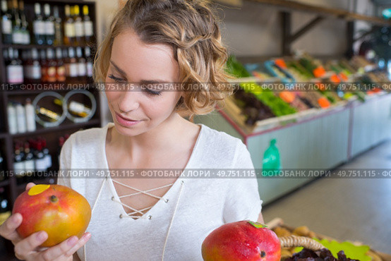 Woman holding mangoes in greengrocers. Стоковое фото, агентство Ingram Publishing / Фотобанк Лори