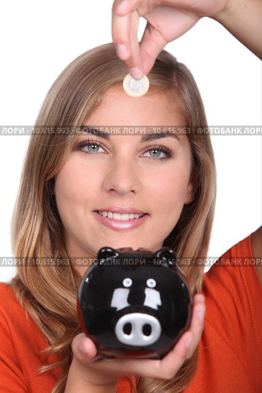 Woman holding piggy bank and coin. Стоковое фото, фотограф Phovoi R. / Smarterpix / Фотобанк Лори