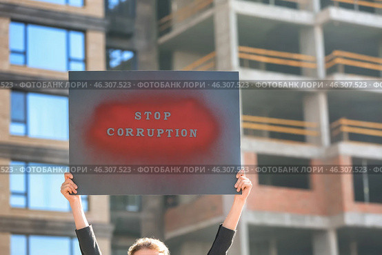 Woman holding placard with text STOP CORRUPTION outdoors. Стоковое фото, фотограф Pixel_shot / Фотобанк Лори