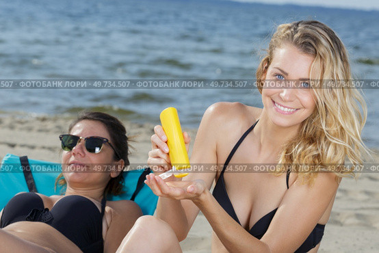 woman holding sunscreen on the beach. Стоковое фото, агентство Ingram Publishing / Фотобанк Лори