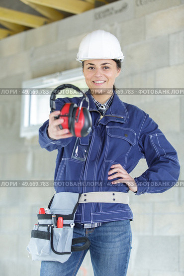 woman in workshop with noise cancelling headphones. Стоковое фото, агентство Ingram Publishing / Фотобанк Лори