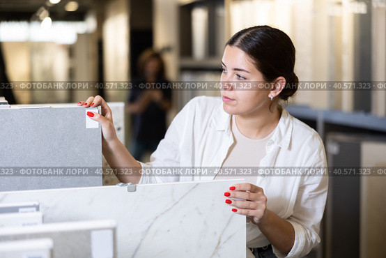 woman is considering MDF boards for internal insulation of residential premises. Стоковое фото, фотограф Яков Филимонов / Фотобанк Лори