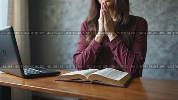 Woman is praying in front of a laptop and a book. Стоковое AI-видео, аниматор Sergey Grishin / Фотобанк Лори
