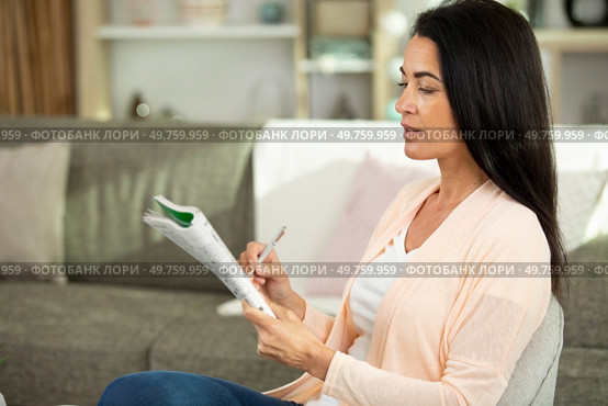 woman is solving crossword puzzles. Стоковое фото, агентство Ingram Publishing / Фотобанк Лори