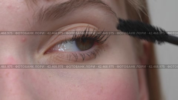 Woman is using tip of mascara brush to apply the product and prevent clumping. Extreme close-up view. Стоковое видео, видеограф А. А. Пирагис / Фотобанк Лори