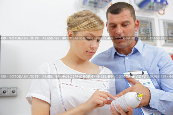 woman looking at exterminator worker spraying insecticide. Стоковое фото, агентство Ingram Publishing / Фотобанк Лори