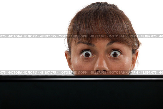 Woman peering over her laptop. Стоковое фото, агентство Ingram Publishing / Фотобанк Лори