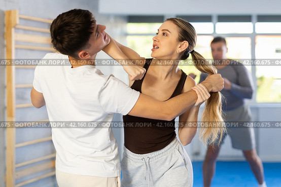 Woman practices blows to the head of a male attacker during self defense training. Стоковое фото, фотограф Яков Филимонов / Фотобанк Лори