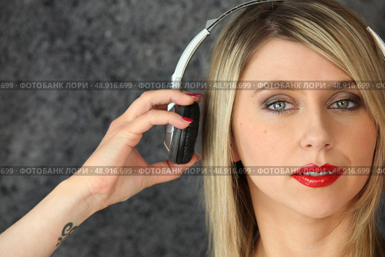 Woman putting on a pair of headphones. Стоковое фото, агентство Ingram Publishing / Фотобанк Лори