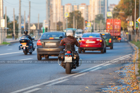Woman riding on city street on her bike, rear view on the urban road. Стоковое фото, фотограф Кекяляйнен Андрей / Фотобанк Лори