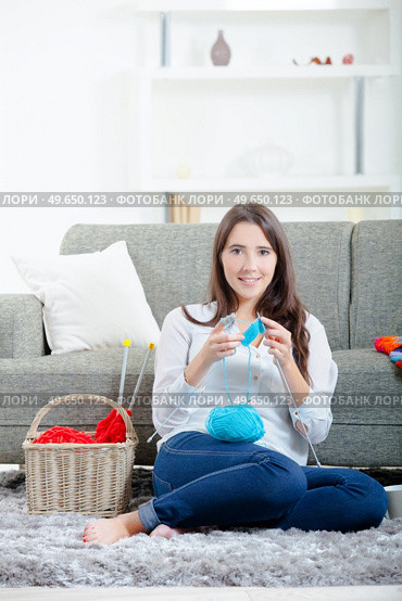 Woman sat on floor knitting. Стоковое фото, агентство Ingram Publishing / Фотобанк Лори