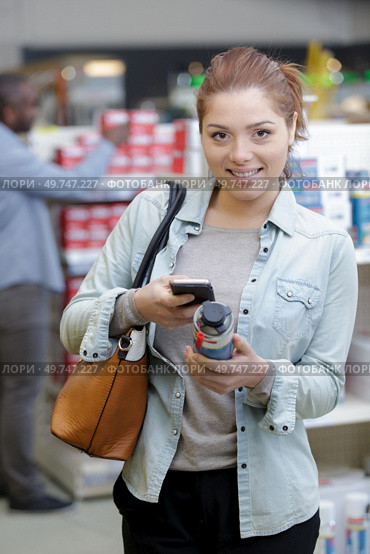 woman selecting paints for interior in household store. Стоковое фото, агентство Ingram Publishing / Фотобанк Лори