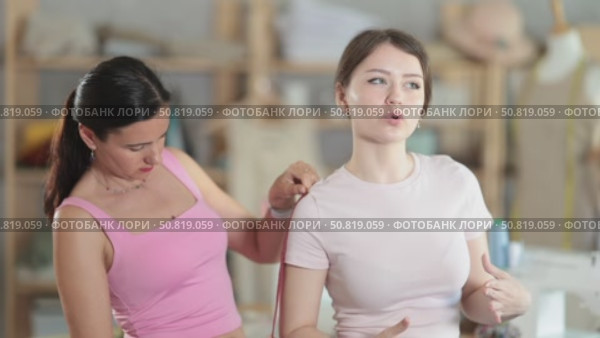 Woman tailor takes measurements from girl client. Стоковое видео, видеограф Яков Филимонов / Фотобанк Лори