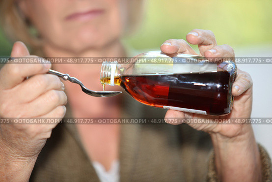 Woman taking cough medicine. Стоковое фото, агентство Ingram Publishing / Фотобанк Лори