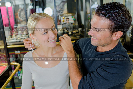 woman trying a necklace with husband at a jewellery shop. Стоковое фото, агентство Ingram Publishing / Фотобанк Лори