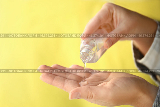 Woman using antibacterial hand gel on color background, closeup. Стоковое фото, фотограф Pixel_shot / Фотобанк Лори