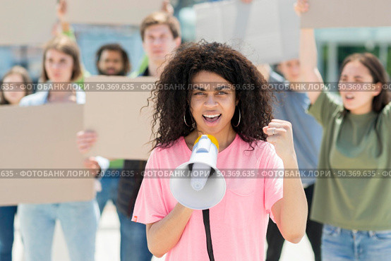 woman with curly hair protesting with megaphone. Стоковое фото, агентство Ingram Publishing / Фотобанк Лори