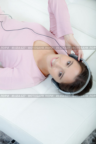 woman with headphones lying down. Стоковое фото, агентство Ingram Publishing / Фотобанк Лори