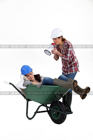 Woman with megaphone yelling at woman asleep. Стоковое фото, агентство Ingram Publishing / Фотобанк Лори