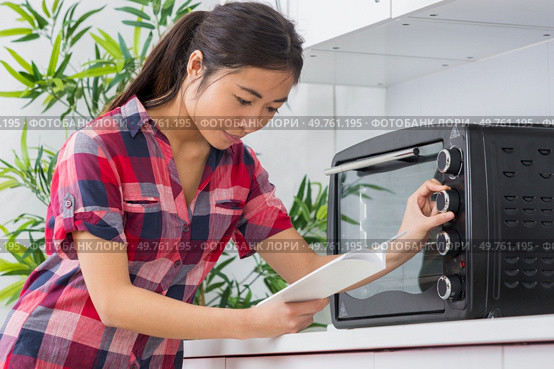 woman with new cooker and instruction manual. Стоковое фото, агентство Ingram Publishing / Фотобанк Лори