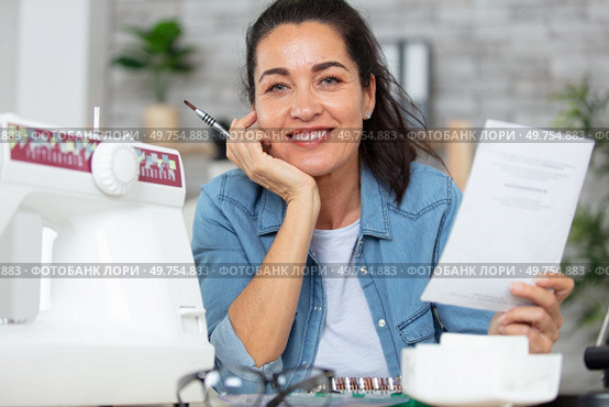 woman with new sewing machine and instructions. Стоковое фото, агентство Ingram Publishing / Фотобанк Лори