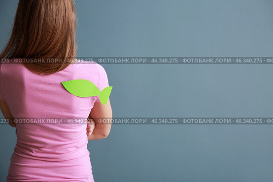 Woman with paper fish on her back against color background. April fools' day prank. Стоковое фото, фотограф Pixel_shot / Фотобанк Лори