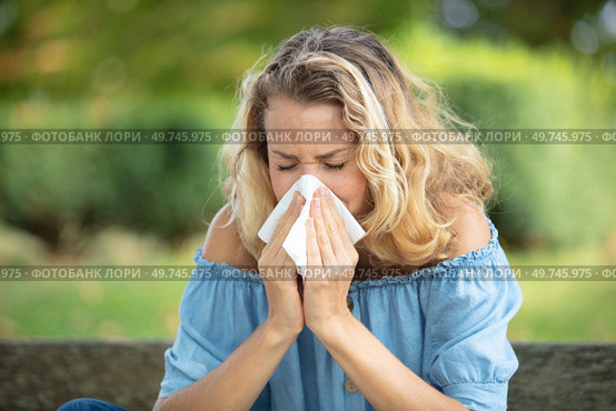 woman with with allergy symptom blowing nose. Стоковое фото, агентство Ingram Publishing / Фотобанк Лори