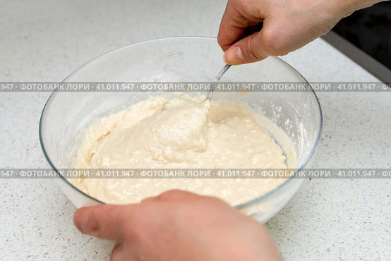 Woman's hands with an yeast dough. The woman is stirring the baking dough in a glass bowl. Женские руки с дрожжевым тестом. Женщина замешивает тесто для выпечки в стеклянной миске. Стоковое фото, фотограф Дмитрий Березнев / Фотобанк Лори