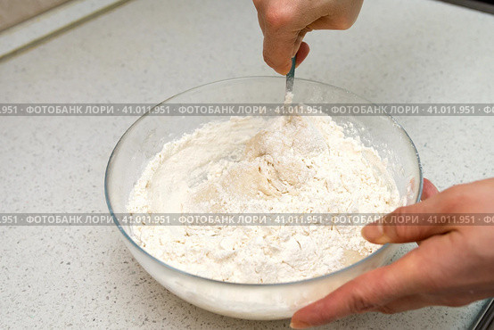 Woman's hands with an yeast dough. The woman is stirring the baking dough in a glass bowl. Женские руки с дрожжевым тестом. Женщина замешивает тесто для выпечки в стеклянной миске. Стоковое фото, фотограф Дмитрий Березнев / Фотобанк Лори