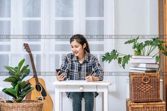 Women sit at the desk and use the phone to coordinate. Стоковое фото, агентство Ingram Publishing / Фотобанк Лори