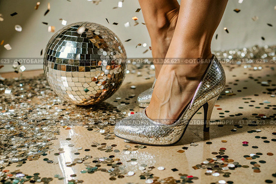 Women's legs in luxurious shiny pumps with heels at a party or disco on the background of a silver mirrored disco ball. The queen of the dance floor. Стоковое AI-изображение, AI-художник Photojuli / Фотобанк Лори