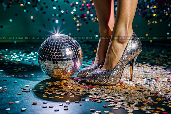 Women's legs in luxurious shiny pumps with heels at a party or disco on the background of a silver mirrored disco ball. The queen of the dance floor. Стоковое AI-изображение, AI-художник Photojuli / Фотобанк Лори