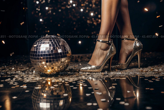Women's legs in luxurious shiny pumps with heels at a party or disco on the background of a silver mirrored disco ball. The queen of the dance floor. Стоковое AI-изображение, AI-художник Photojuli / Фотобанк Лори