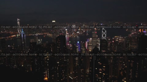 Wonderful aerial view of skyscrapers in downtown and Victoria Harbor in Hong Kong at night. Awesome cityscape. Hong Kong is a popular tourist destination of Asia. Редакционное видео, видеограф Ирина Михайличенко / Фотобанк Лори