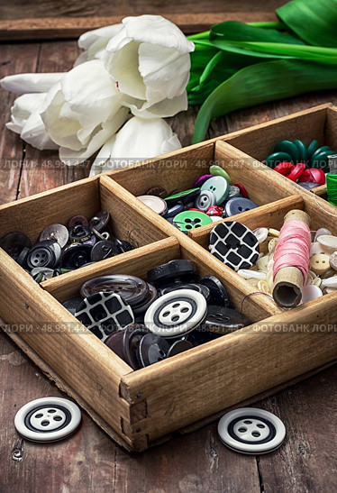 wooden box with buttons and thread on the background of bouquet of white tulips. image is tinted in vintage style. thread and buttons. Стоковое фото, агентство Ingram Publishing / Фотобанк Лори
