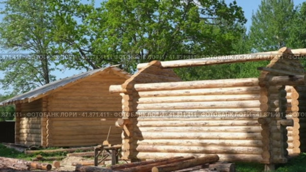Wooden log building, housing. Log cabin. Wood House exterior. Country Green forest on background. Built a cottage on construction site. Wooden frame of the home from bar. Production. Carpentry concept. Стоковое видео, видеограф Марина Демидюк / Фотобанк Лори