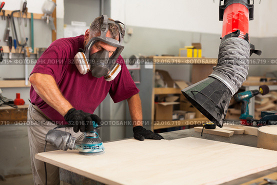 Worker grinds the wood plank of angular grinding machine. Стоковое фото, фотограф Яков Филимонов / Фотобанк Лори