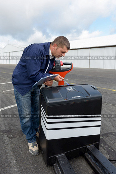 worker inspecting serial number of heavy loader cart. Стоковое фото, агентство Ingram Publishing / Фотобанк Лори