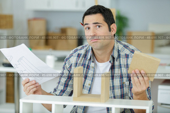 worker install furniture with instruction. Стоковое фото, агентство Ingram Publishing / Фотобанк Лори
