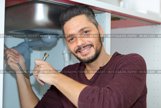 worker with gripper in had is fixing a pipe. Стоковое фото, агентство Ingram Publishing / Фотобанк Лори