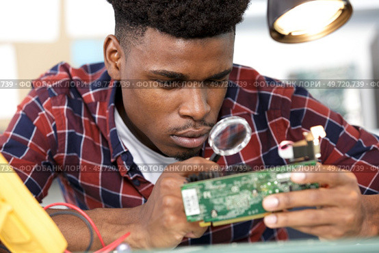 workplace with soldering iron microcircuit magnifying glass magnifying glass. Стоковое фото, агентство Ingram Publishing / Фотобанк Лори