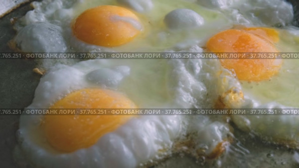 Яйца жарят на сковороде. Стоковое видео, видеограф Valeryi Vysotkov / Фотобанк Лори