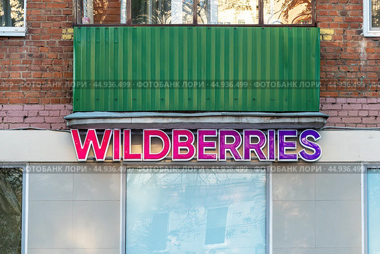 Яркая вывеска WILDBERRIES на стене дома. Пункт выдачи заказов. (2024 год). Редакционное фото, фотограф Лариса Гордеева / Фотобанк Лори