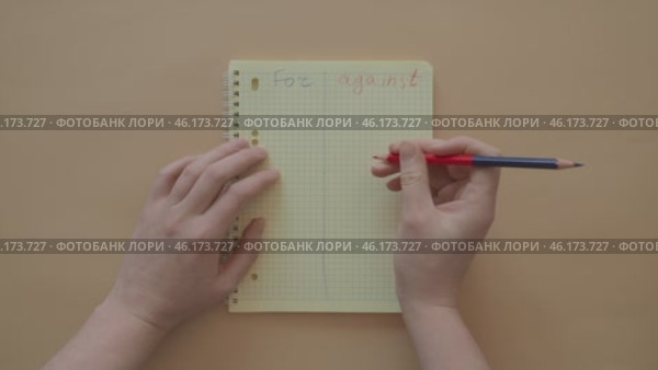 Yellow notepad for and against, reasons to do, postpone. Lined notebook for list of answers on pale background, hands with marker writing comparison. Account of reasons, doubts. Shopping time concept. Стоковое видео, видеограф Елизавета Малкова / Фотобанк Лори