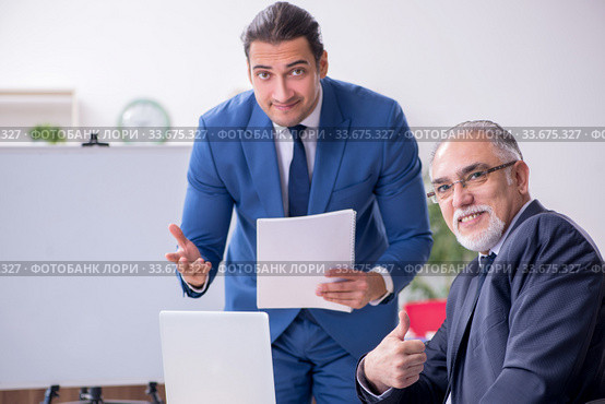 Yound and old employees in business presentation concept. Стоковое фото, фотограф Elnur / Фотобанк Лори